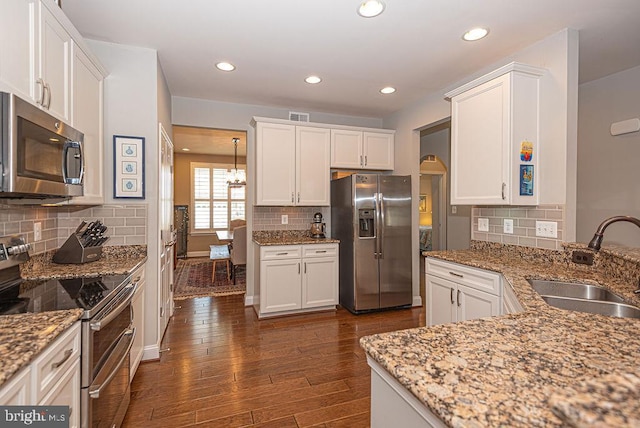 kitchen with stainless steel appliances, white cabinetry, and sink