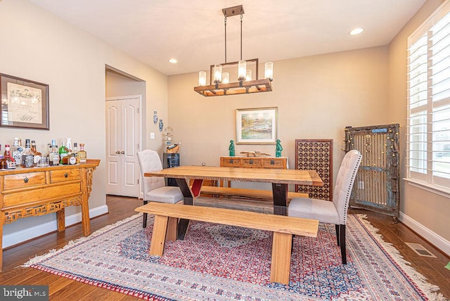 dining space featuring dark hardwood / wood-style flooring and an inviting chandelier