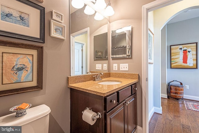 bathroom featuring vanity, wood-type flooring, and toilet