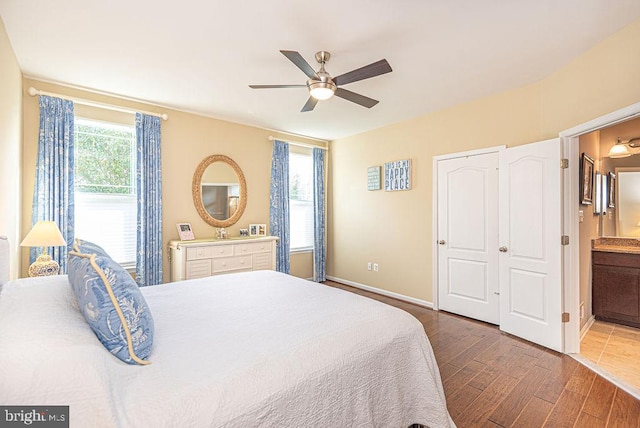 bedroom with multiple windows, ceiling fan, hardwood / wood-style floors, and ensuite bathroom