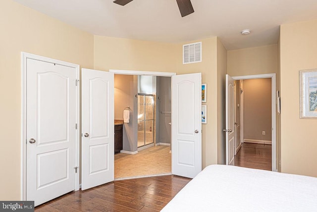 bedroom with dark hardwood / wood-style floors, ceiling fan, and connected bathroom