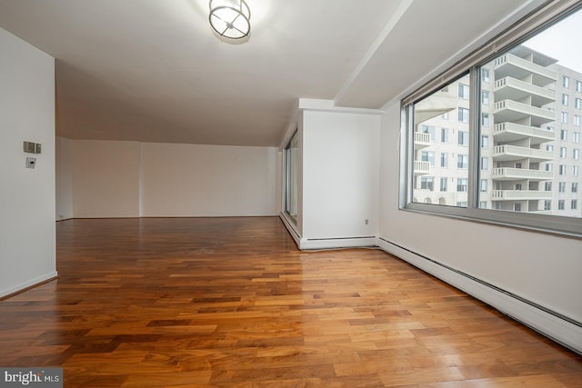 bonus room with a baseboard radiator and wood finished floors