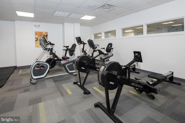 gym with carpet flooring and a paneled ceiling