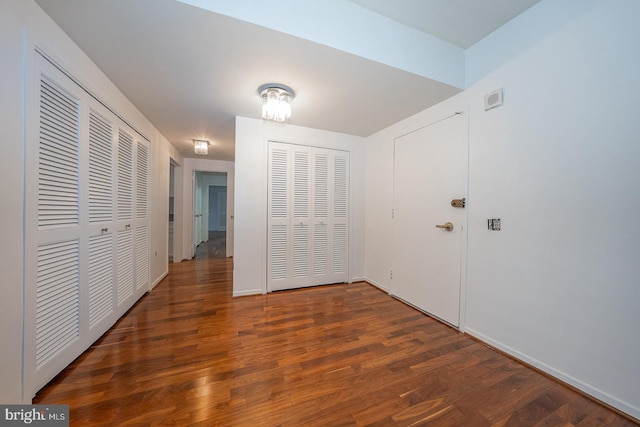 corridor featuring wood finished floors and baseboards