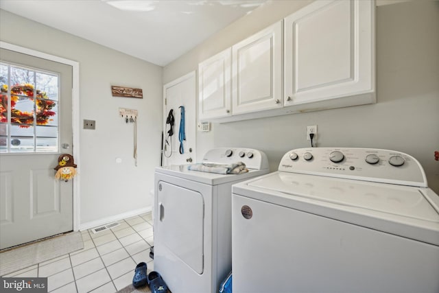 laundry room featuring light tile patterned flooring, cabinets, and washer and dryer