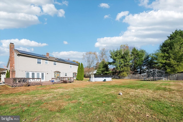 view of yard with a pool side deck and a trampoline