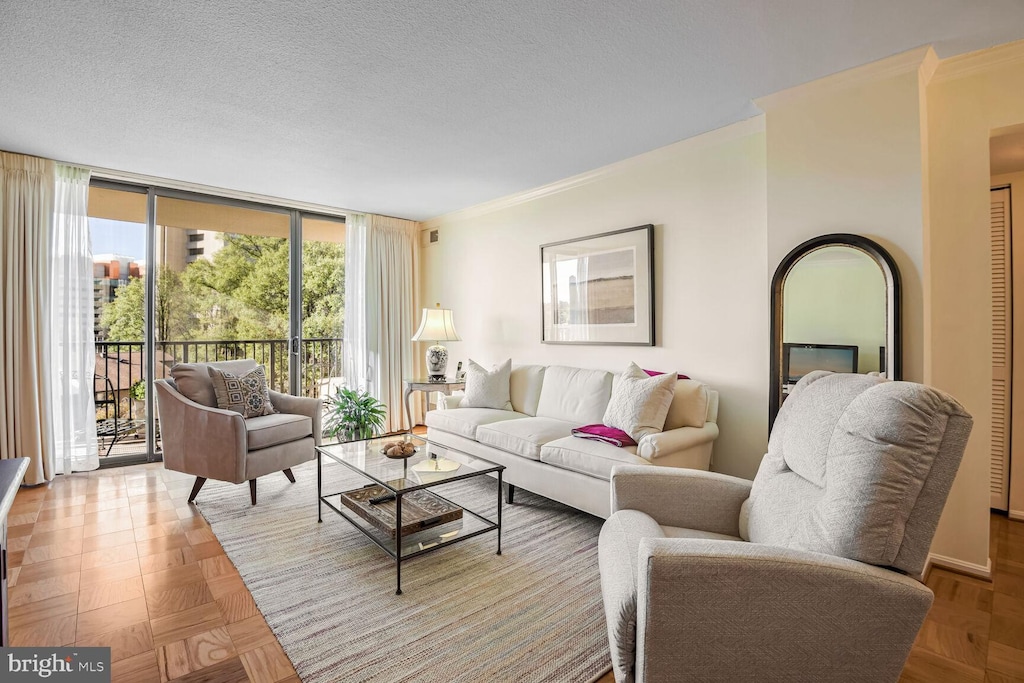 living room featuring a textured ceiling, light parquet floors, and crown molding