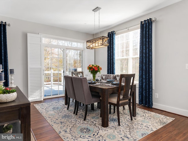 dining room with plenty of natural light, a notable chandelier, and dark hardwood / wood-style floors