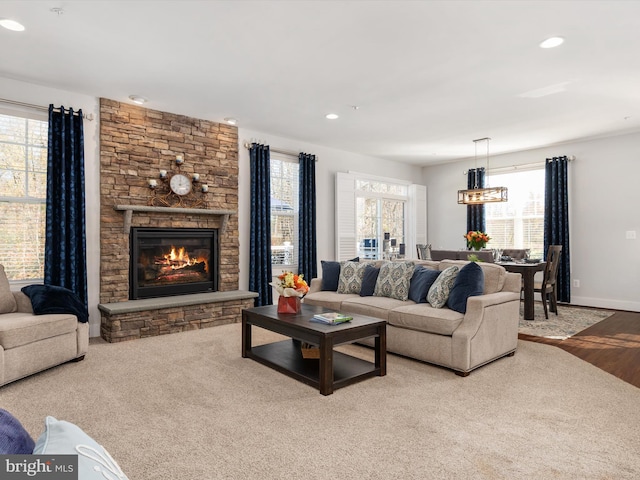 living room with a fireplace, a healthy amount of sunlight, and light wood-type flooring