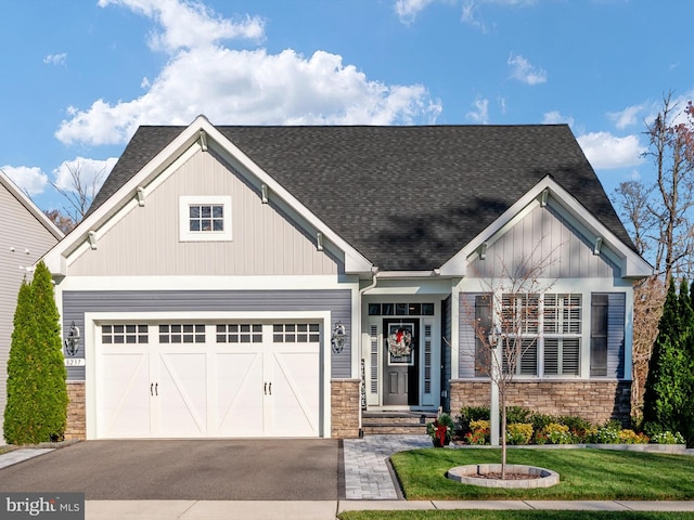 craftsman house with a garage and a front lawn