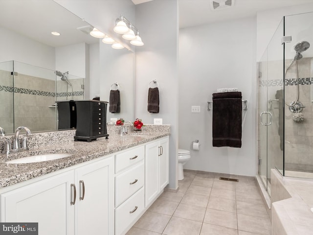 bathroom with toilet, vanity, tile patterned floors, and a shower with shower door