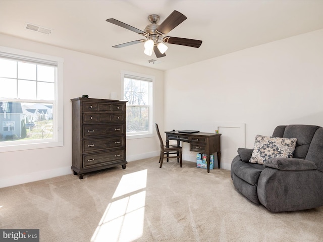 carpeted home office featuring ceiling fan