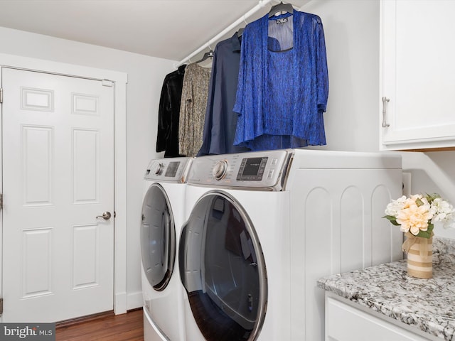 clothes washing area featuring separate washer and dryer, cabinets, and dark hardwood / wood-style floors