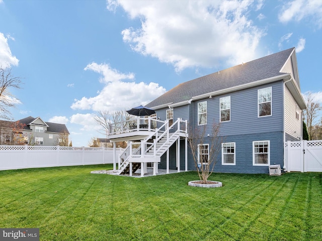 rear view of house featuring a wooden deck and a yard