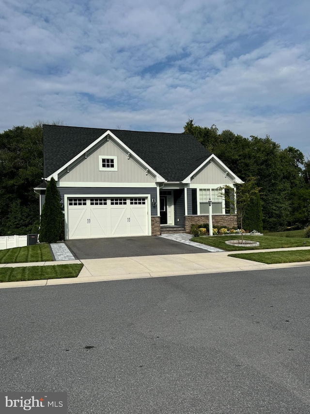 craftsman-style home featuring a garage and a front lawn