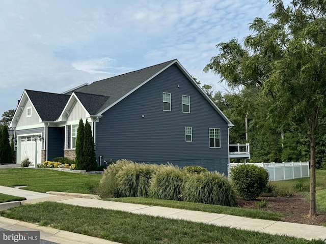 view of side of home with a garage and a lawn