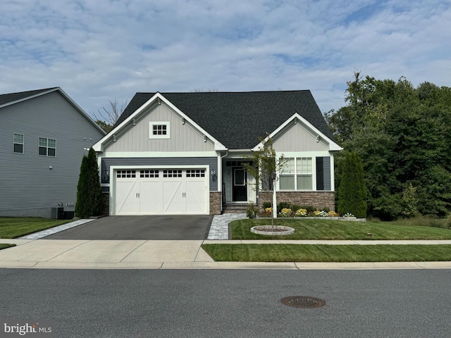 craftsman house with central AC unit, a garage, and a front yard