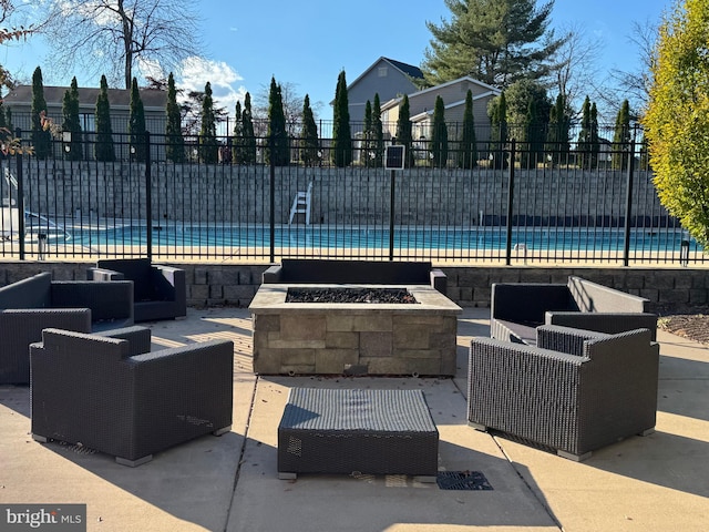 view of swimming pool with a patio and an outdoor living space with a fire pit