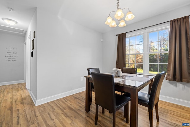 dining area featuring light hardwood / wood-style floors and an inviting chandelier