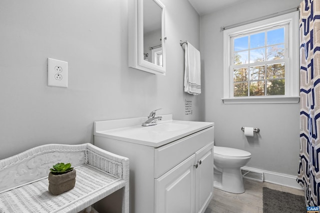 bathroom with wood-type flooring, toilet, and vanity