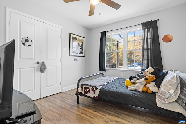 bedroom featuring hardwood / wood-style flooring, ceiling fan, and a closet