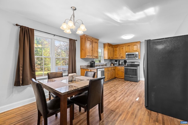 dining area featuring sink, an inviting chandelier, and light hardwood / wood-style flooring