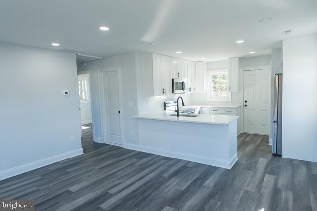 122 Roselawn Rd, Annapolis, MD 21403 - kitchen with stainless steel appliances, a peninsula, recessed lighting, dark wood-type flooring, and white cabinetry