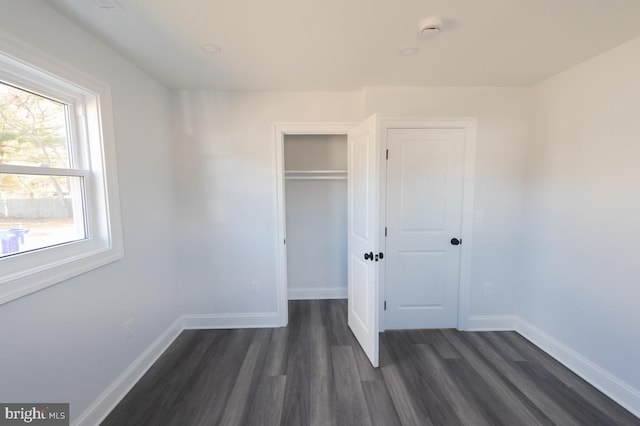 unfurnished bedroom featuring dark hardwood / wood-style flooring and a closet