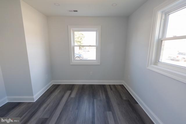 spare room featuring dark wood-type flooring