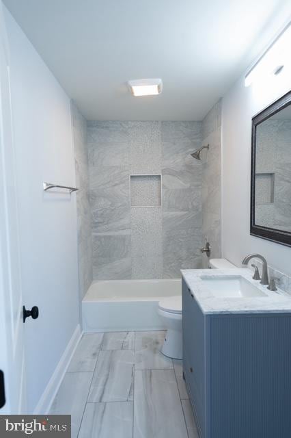 full bathroom with vanity, toilet, and tiled shower / bath