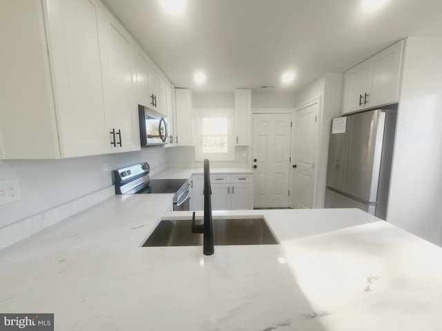 kitchen featuring white cabinets, sink, and appliances with stainless steel finishes