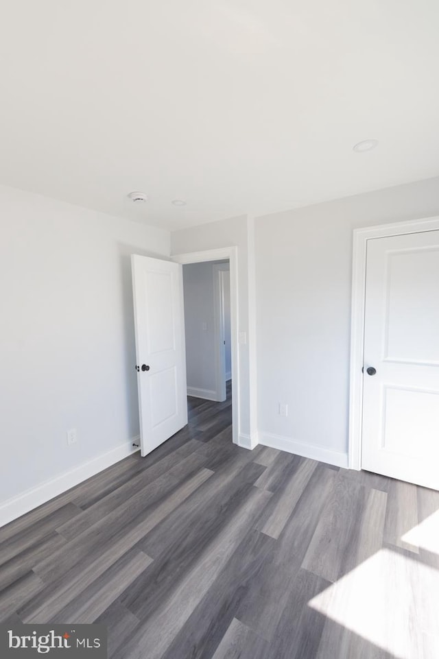 empty room with dark hardwood / wood-style flooring