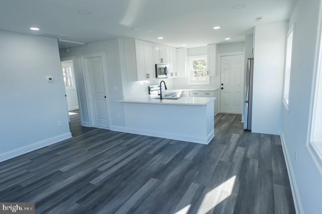 122 Roselawn Rd, Annapolis, MD 21403 - kitchen with appliances with stainless steel finishes, a peninsula, dark wood-type flooring, white cabinets, and light countertops