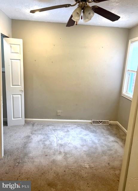 spare room featuring ceiling fan and a textured ceiling