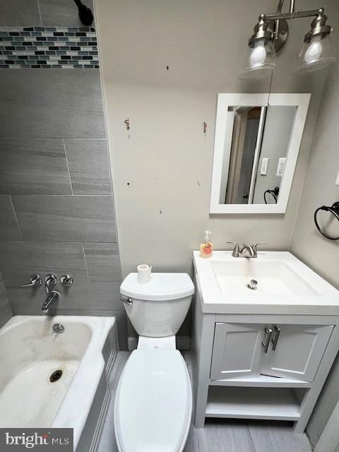 full bathroom with toilet, vanity, and tiled shower / bath