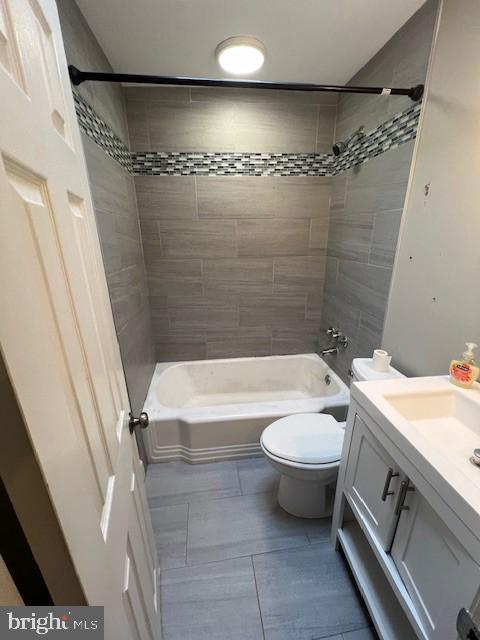 full bathroom featuring toilet, vanity, and tiled shower / bath