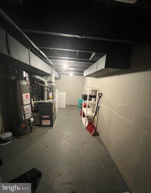 basement featuring heating unit, washing machine and dryer, and water heater