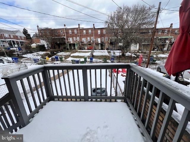 view of snow covered back of property