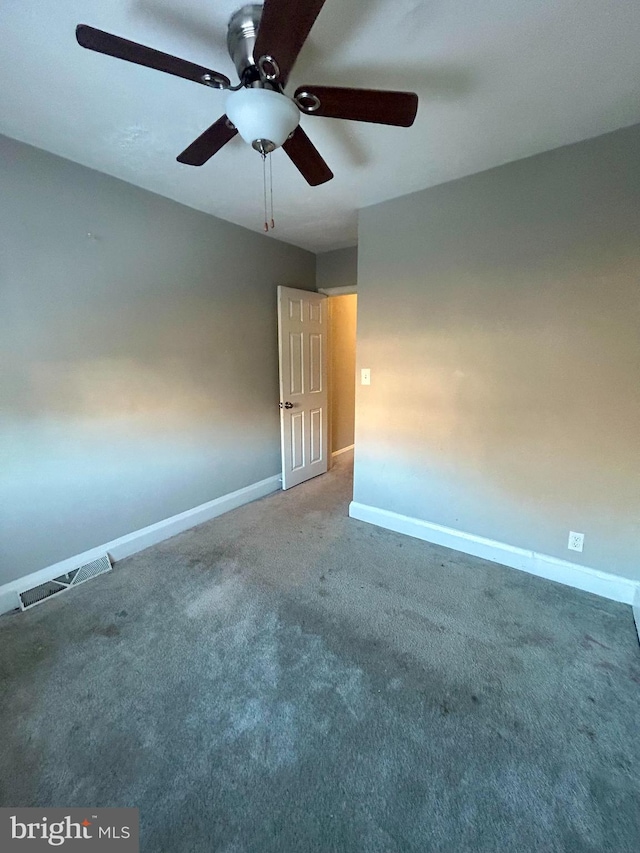 carpeted spare room featuring ceiling fan