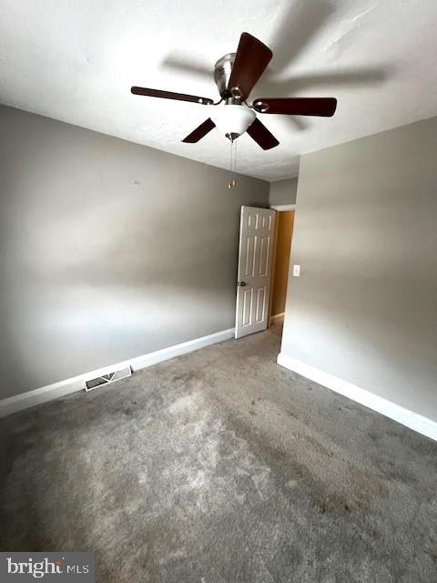 carpeted spare room featuring ceiling fan