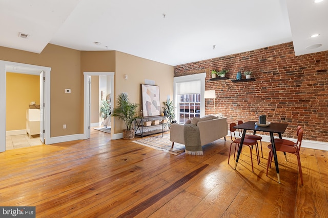 interior space with light hardwood / wood-style flooring and brick wall