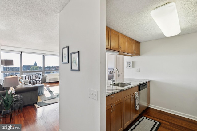 kitchen featuring light stone counters, a textured ceiling, sink, stainless steel dishwasher, and dark hardwood / wood-style floors