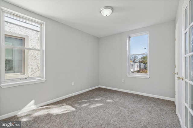 carpeted spare room featuring plenty of natural light