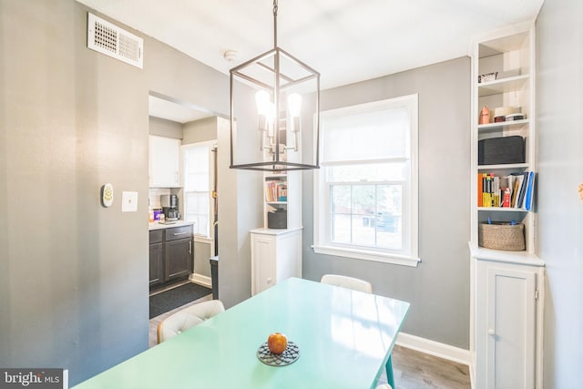 dining room with hardwood / wood-style floors and a chandelier