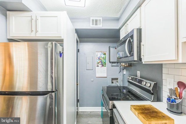 kitchen with stainless steel appliances, white cabinetry, tasteful backsplash, and dark hardwood / wood-style floors