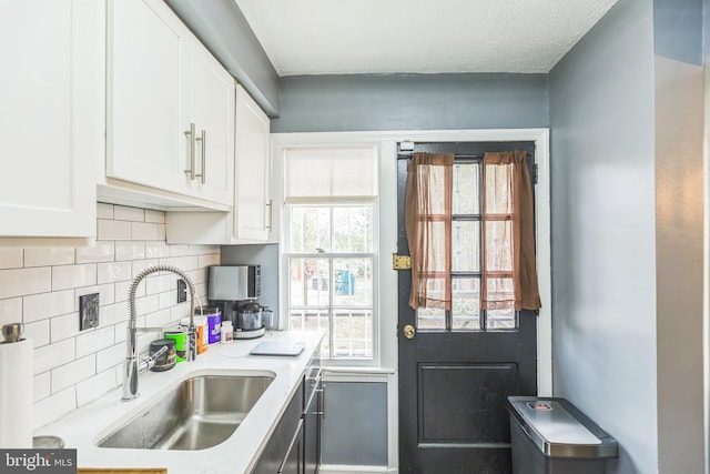 kitchen with white cabinets, tasteful backsplash, and sink