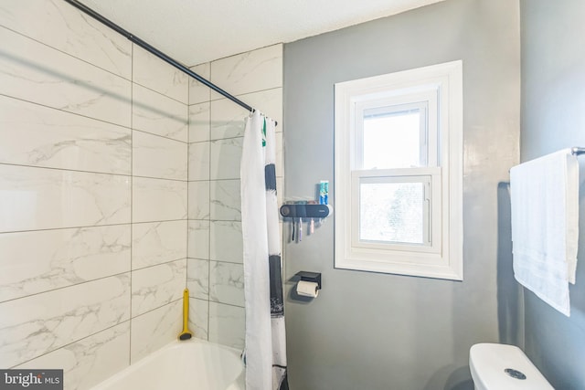 bathroom featuring shower / bath combo and toilet