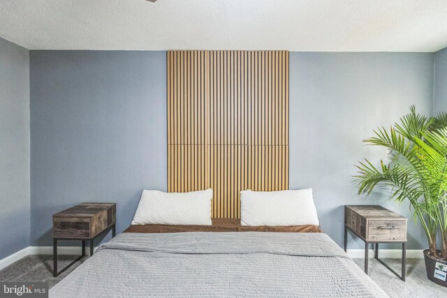 bedroom featuring carpet flooring and a textured ceiling