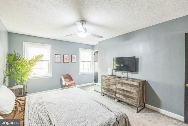 carpeted bedroom featuring a textured ceiling, multiple windows, and ceiling fan