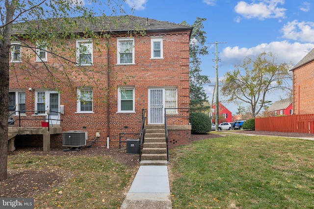 view of front of home featuring cooling unit and a front lawn